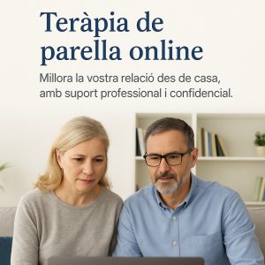 Parella de mitjana edat asseguda al sofà, concentrada en una videotrucada. Entorn càlid i acollidor amb prestatgeries al fons. Imatge promocional per a la teràpia de parella online des de casa.